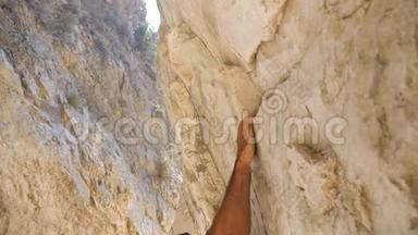 年轻的肌肉男在岩石上小心翼翼地攀爬。 强壮的人在摇滚<strong>巅峰</strong>上奋起努力。 登山者
